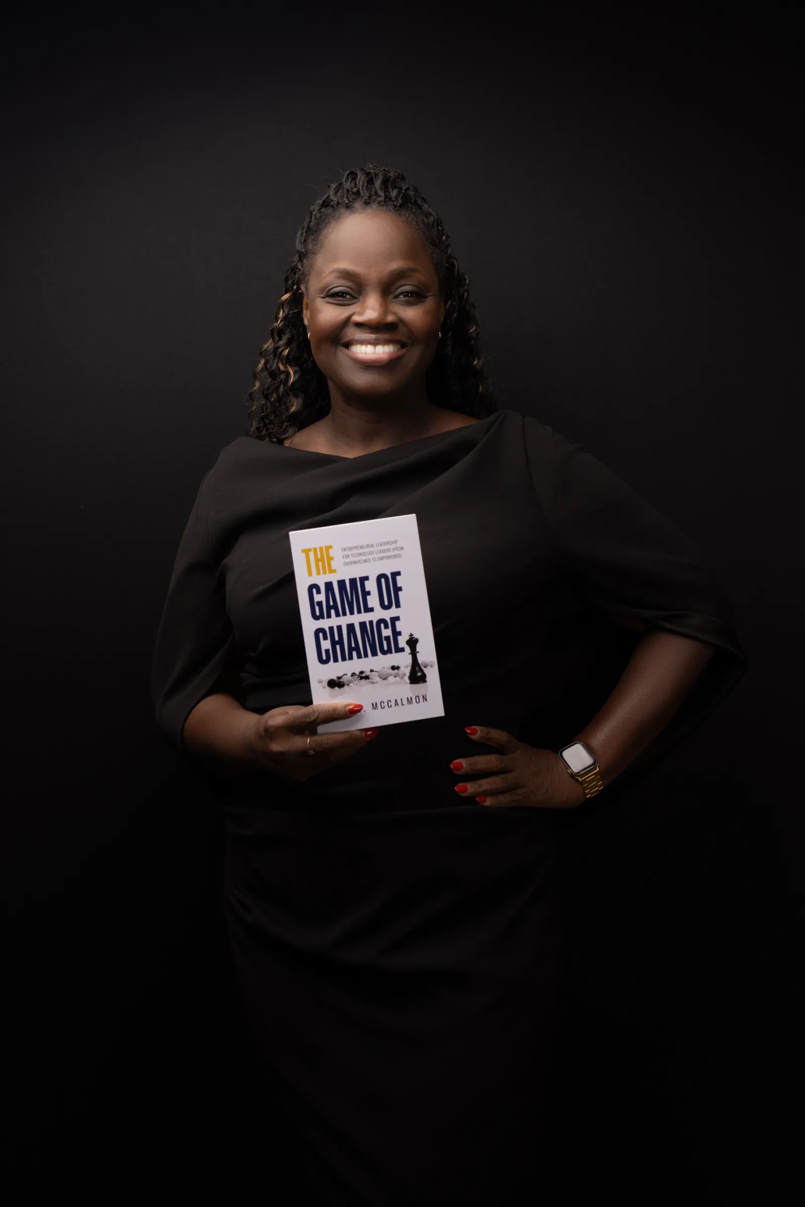 Adie O. McCalmon smiling and holding The Game of Change