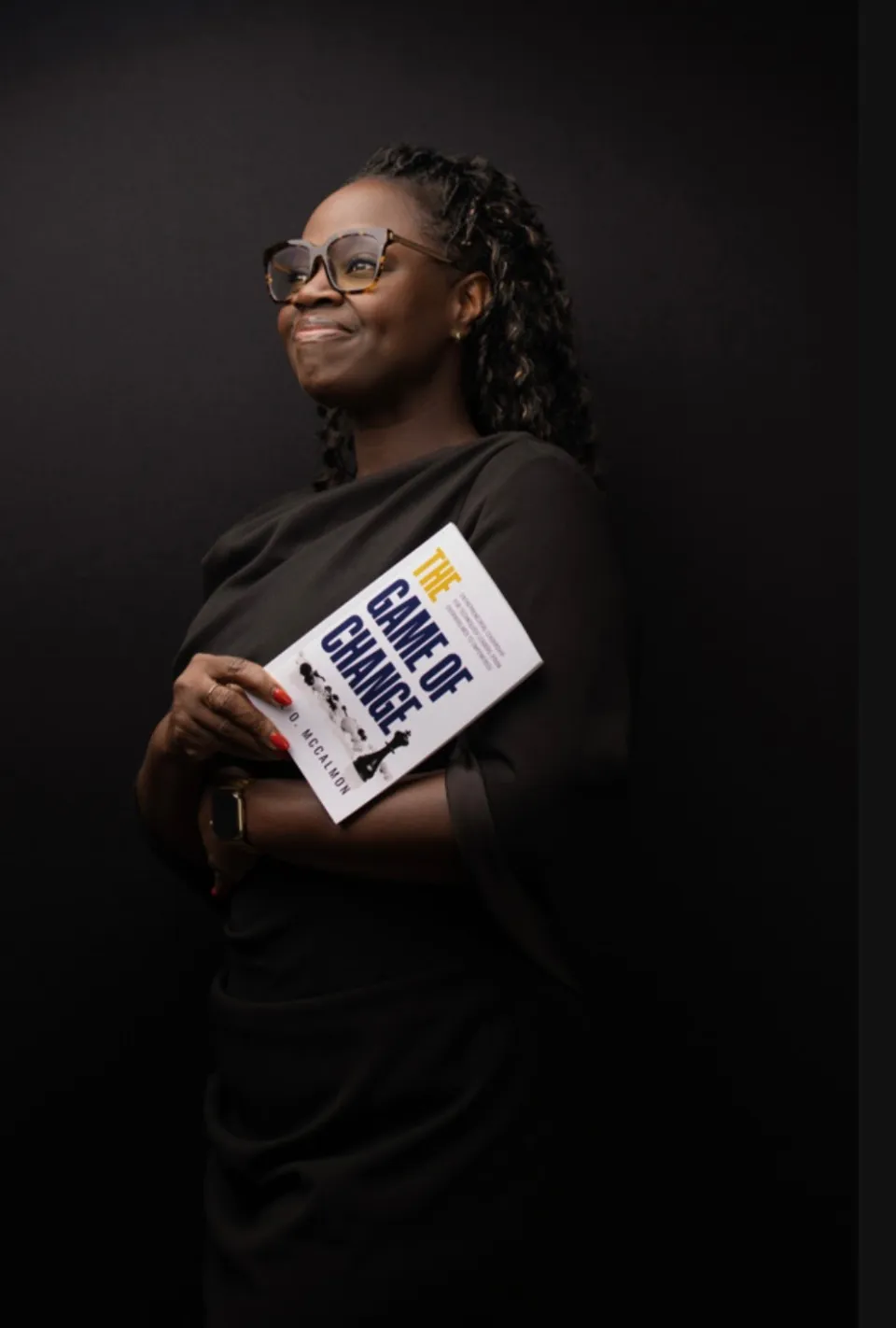 Adie O. McCalmon holding her book and looking ahead